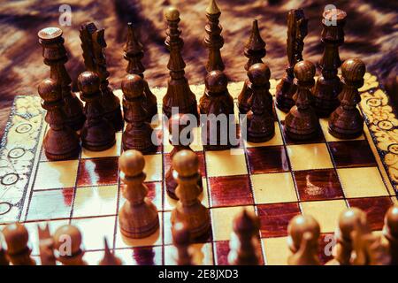 Jeu d'échecs en bois d'époque avec ouverture de gambit queen, vue rapprochée de l'échiquier. Banque D'Images