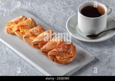 Cuisine maison, petits gâteaux faits maison avec fromage cottage et une tasse de café sur fond gris Banque D'Images