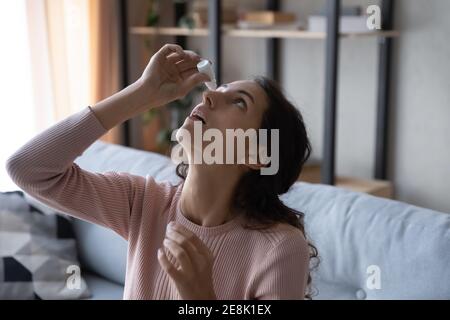 Prise de vue à la tête jeune femme caucasienne utilisant des gouttes pour les yeux médicaux. Banque D'Images