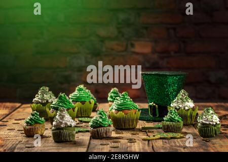 Happy St Patricks Day cupcakes avec des décorations vertes sur fond de bois de style vintage. Banque D'Images
