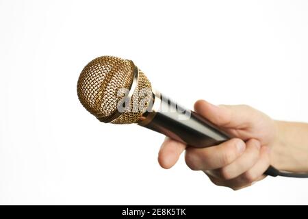 homme tient le microphone doré isolé sur un fond blanc. concept d'interview. pour le design ou la décoration Banque D'Images