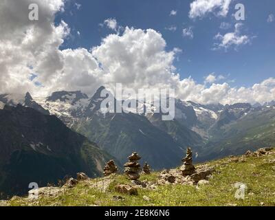 Montagne enneigée contre ciel nuageux. Des nuages blancs qui flottent sur le ciel bleu au-dessus de la crête de montagne couverte de neige le jour ensoleillé dans la nature. Banque D'Images