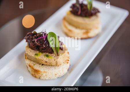 Pâté de foie de canard maison avec bruschetta, confiture de légumes verts et d'oignons rouges, mise au point sélective, gros plan Banque D'Images