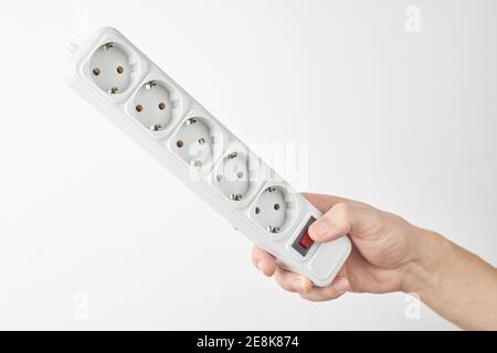 la personne tient une bande de cordon d'alimentation blanche vide. espace extérieur. isolé sur fond blanc Banque D'Images