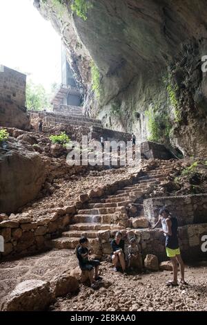 Les impressionnantes grottes du ciel et de l'enfer dans le sud-est de la Turquie, où une arche naturelle encadre un escalier menant aux profondeurs mystérieuses. Banque D'Images