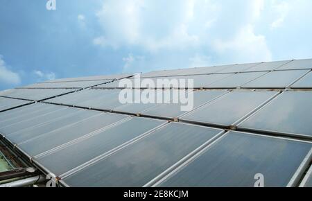 Chaleur solaire pour l'approvisionnement en eau chaude dans le bâtiment avec lumière du soleil et ciel bleu - concept d'économie d'énergie Banque D'Images