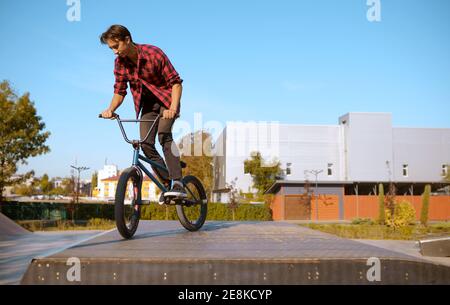 BMX Biker faisant le tour, adolescent dans le skate Park Banque D'Images