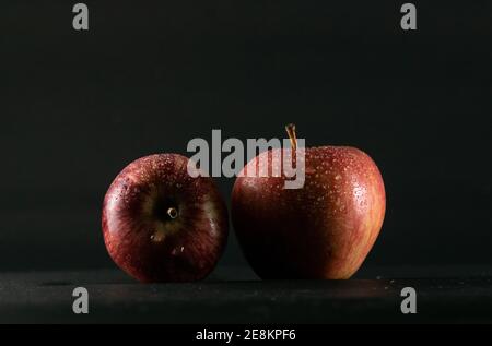 pommes rouges sur fond noir et gouttelettes d'eau il Banque D'Images