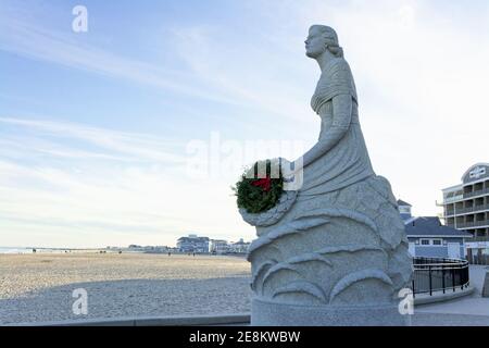 Hampton Beach - Hampton, New Hampshire - le monument de la Dame de la mer contre la mer et le sable tandis que le soleil se couche sur une soirée d'hiver hors saison. Banque D'Images