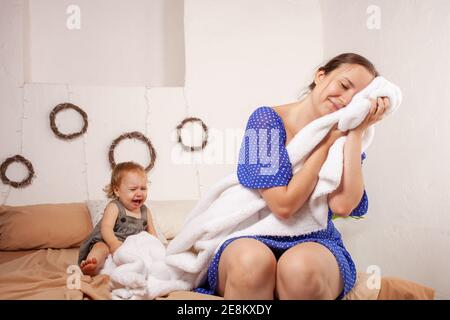 Maman imagine un rêve doux sans bébé. Le bébé hurle, hystérique. La femme veut dormir et prendre une pause du bébé. Rêves de repos de Banque D'Images