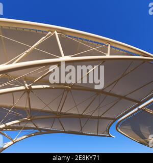 Gros plan d'une structure de traction moderne sur un ciel bleu clair, toit en toile à membrane avec poteaux en acier blanc. Photographie, plein format. Banque D'Images