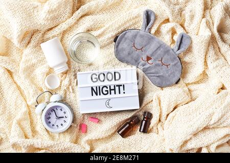 Masque de sommeil, réveil, bouchons d'oreille, huiles essentielles et pilules. Concept créatif de sommeil sain. Flat lay, vue de dessus. Bonne nuit, hygiène du sommeil, moi Banque D'Images