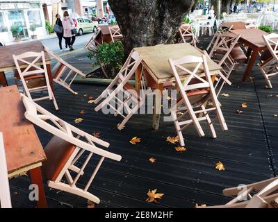 Chaises et tables en bois vides à une taverne en bord de route, Nafpaktos (Lepanto), Grèce Banque D'Images