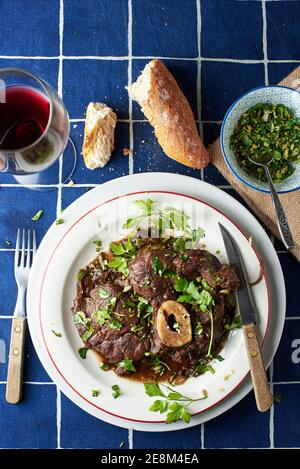 Ossobuco alla milanais habillé de gremolata sur une table d'une trattoria traditionnelle. Cuisine italienne. Banque D'Images