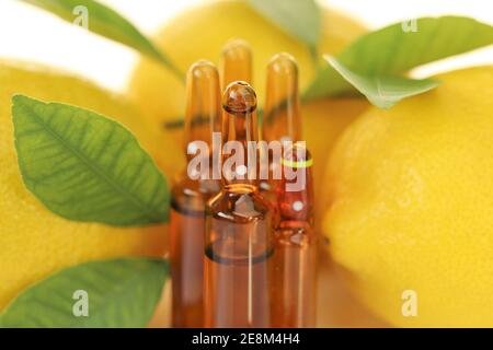 Vitamine C injection.SOLUTION de vitamine C dans un jeu d'ampoules de verre brun, citrons sur fond blanc avec réflexion. Sérum avec vitamine C. organique Banque D'Images