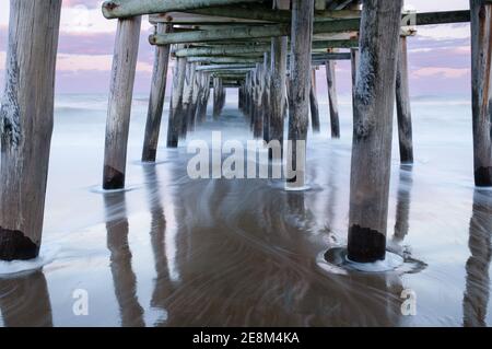 Le quai de pêche Sandbridge à Virginia Beach au coucher du soleil, avec une longue exposition rendant l'eau soyeuse et rêveuse Banque D'Images