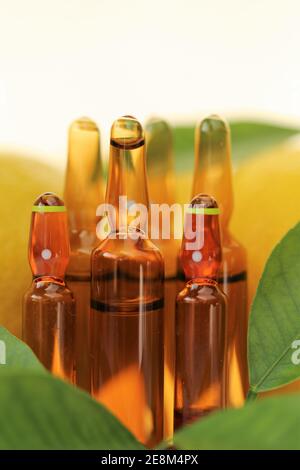 Vitamine C injection.UNE solution de vitamine C dans un jeu d'ampoules de verre brun, citrons . ampoules et sérum à la vitamine C. concept de cosmétiques organiques. Banque D'Images