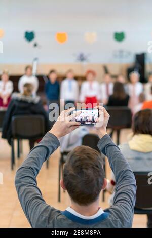 Parents à l'exécution d'enfants à la maternelle ou à l'école. Enfants sur scène. De nombreux parents regardent les enfants dans le hall pendant Banque D'Images