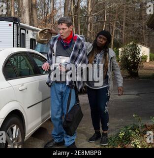 Jonesboro, GA, États-Unis. 31 janvier 2021. Un personnel de soutien financé par Medicaid escorte Tim McBroom à sa voiture pour un trajet en ville comme activité de l'après-midi. Mike et Sheila McBroom sont souvent éveillés la nuit, remplis d'anxiété au sujet de leur fils adultes handicapés, Tim's future. Tim, 36 ans, qui est non verbal et connaît un autisme grave, a des crises et des problèmes de comportement. McBroom et sa femme font de leur mieux pour offrir à leur fils un environnement sûr et sécuritaire dans leur maison de Jonesboro, avec l'aide quotidienne du personnel de soutien financé par Medicaid. Mais a proposé des réductions de ces services financés par Medicaid Banque D'Images