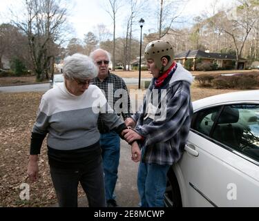 Jonesboro, GA, États-Unis. 31 janvier 2021. Mike et Sheila McBroom se préparer pour un trajet avec le fils handicapé Tim. Les McBrooms sont souvent éveillés la nuit, remplis d'inquiétude quant à l'avenir de Tim's. Tim, 36 ans, qui est non verbal et connaît un autisme grave, a des crises et des problèmes de comportement. McBroom et sa femme font de leur mieux pour offrir à leur fils un environnement sûr et sécuritaire dans leur maison de Jonesboro, avec l'aide quotidienne du personnel de soutien financé par Medicaid. Mais les réductions proposées à ces services financés par Medicaid bouleversent la vie de leur fils s. Les responsables de l'incapacité de Géorgie's sont en cours Banque D'Images