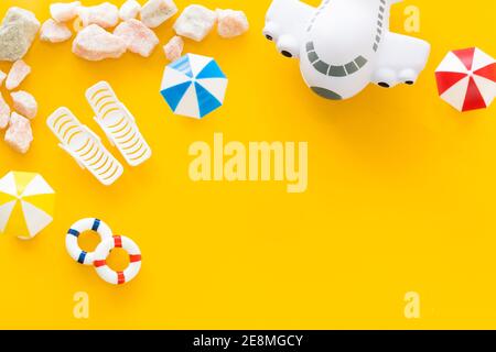 plage au bord de la mer. Chaises longues et parasols miniatures. Plan. Place pour le texte, fond jaune. Concept de voyage de vacances Banque D'Images