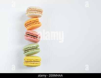 Composition avec de délicieux macarons français multicolores ou macarons sur un arrière-plan clair avec espace de copie Banque D'Images