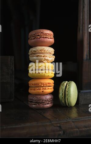 Pile de délicieux macarons français classiques ou macarons sur un vieux panneau latéral sombre vintage Banque D'Images