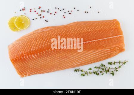 Filet de saumon entier frais et cru avec assaisonnement sur fond blanc Banque D'Images