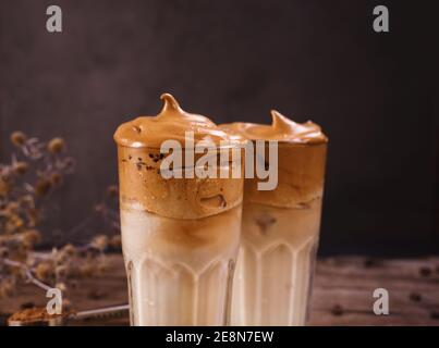 Café Dalgona. Boisson fouettée à glacer avec café instantané populaire en Corée cocktail crémeux dans de grands verres. Photographie de nourriture sombre Banque D'Images