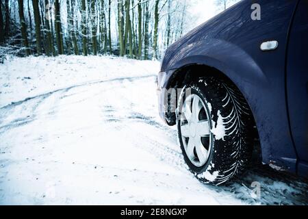 Partie d'une voiture sur une route de campagne recouverte de neige, danger en raison de conditions glissantes lors de la conduite en hiver, concept de sécurité de la circulation, espace de copie, s Banque D'Images