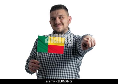Homme blanc tenant un drapeau du Bénin et pointe vers l'avant en face de lui isolé sur un fond blanc Banque D'Images