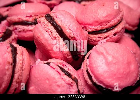 De nombreux petits gâteaux roses français en gros plan. Macarons roses de style macro. Banque D'Images