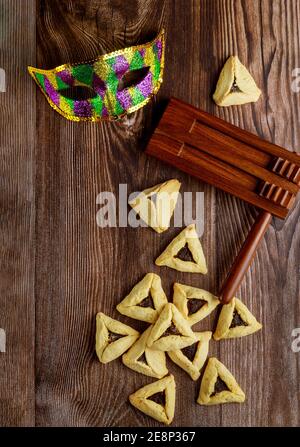 Gragger avec masque de carnaval sur fond de bois. Vacances juives Purim. Banque D'Images