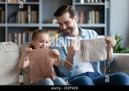 Bonne petite fille de 7s enfant de créer des vêtements chauds avec le père. Banque D'Images