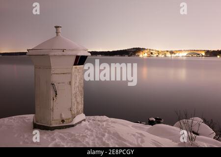 Phare blanc sur la côte de Bogesundslandet en direction de Lidingö, en Suède, près de Stockholm, pendant une nuit d'hiver Banque D'Images