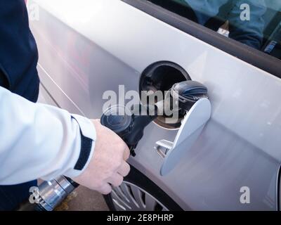 Homme adulte remplissant sa voiture de carburant. Photo de haute qualité Banque D'Images