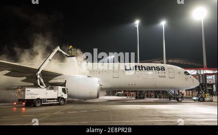 Hambourg, Allemagne. 31 janvier 2021. Un Airbus A350-900 de Lufthansa est stationné à l'aéroport de Hambourg ce soir en train d'être dégivré. L'appareil a pris le vol le plus long de l'histoire de Lufthansa en avion pour passagers sans escale, sa destination étant la base militaire de Mount Pleasant sur les îles Falkland, à 13,700 kilomètres de là. Credit: Daniel Bockwoldt/dpa/Alay Live News Banque D'Images