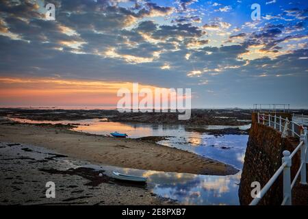 Image du port de la Rocque au lever du soleil avec des nuages et une mer calme. Îles Jersey Channel. Banque D'Images