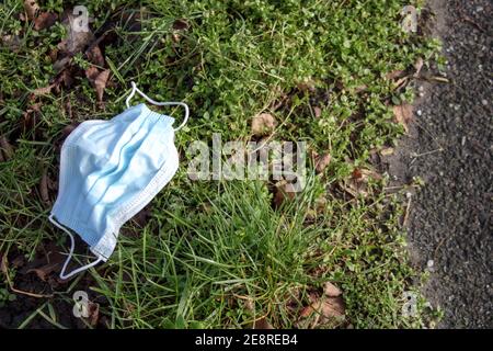 Le masque médical utilisé doit être mis au rebut en dehors de la route. Déchets pendant la pandémie de COVID-19 Banque D'Images