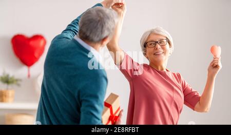 Couple âgé le jour de la Saint-Valentin. Joyeuse belle femme âgée dansant avec son mari. Banque D'Images