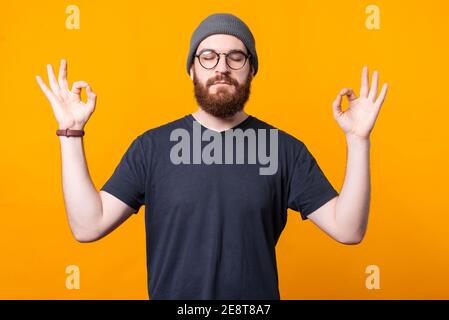 Un jeune hipster est de rester calme et détendu dans un positioin zen. Banque D'Images