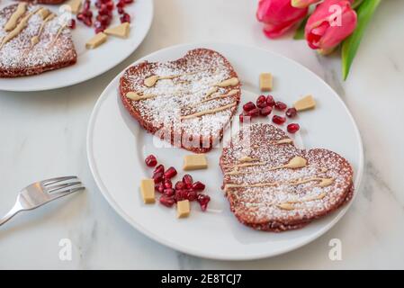 crêpes en velours rouge en forme de coeur sur une table Banque D'Images