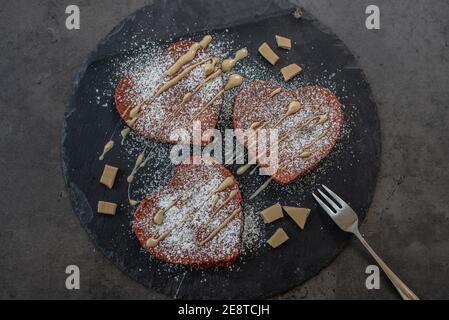 crêpes en velours rouge en forme de coeur sur une table Banque D'Images