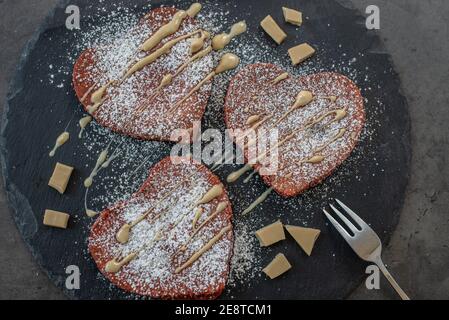 crêpes en velours rouge en forme de coeur sur une table Banque D'Images