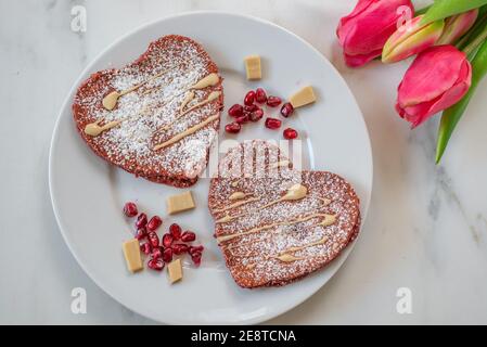 crêpes en velours rouge en forme de coeur sur une table Banque D'Images