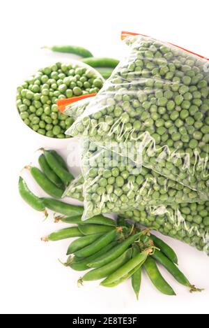 Composition avec légumes surgelés biologiques sur fond blanc. Petits pois verts dans l'emballage Banque D'Images