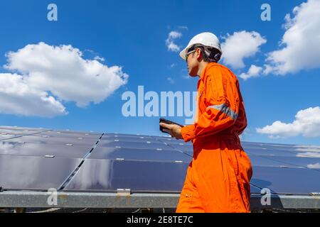 La ferme solaire (panneau solaire) avec des ingénieurs marchent pour vérifier le fonctionnement du système, énergie alternative pour conserver l'énergie du monde, photovoltaïque Banque D'Images