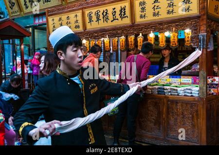 Faire des bonbons dans la rue martelé. Beiyuanmen Street dans le quartier musulman, Xi'an, province du Shaanxi, en Chine. Banque D'Images