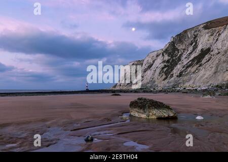 La lune de l'aube se dresse à marée basse près du phare À Beachy Head East Sussex sud-est de l'Angleterre Banque D'Images