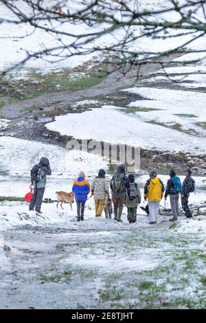 Un groupe de marcheurs se préparant à marcher sur Rough Tor dans la neige sur Bodmin Moor en Cornouailles. Banque D'Images